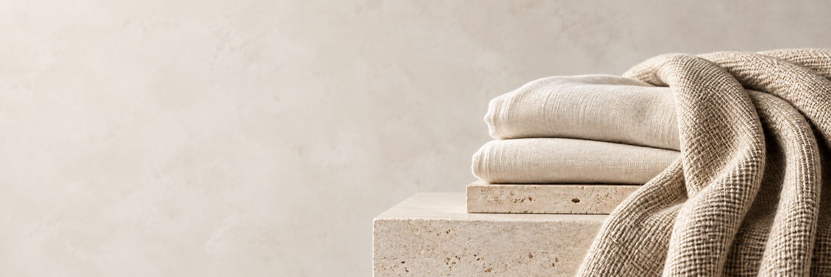 Soft ivory linen and woven textiles in a warm stone setting
